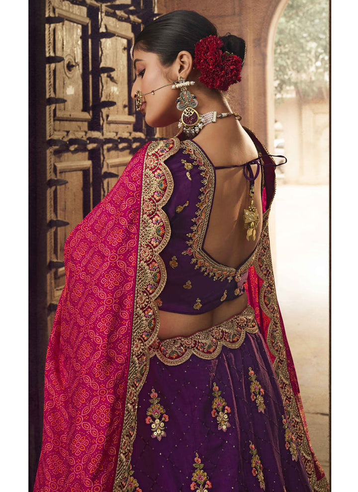 Image: Women in Purple Designer Wedding Wear Lehenga Choli with Embroidery Work. The lehenga choli is in a beautiful shade of purple and adorned with intricate embroidery work. This ensemble exudes elegance and charm, making it a perfect choice for a wedding or special occasion.
