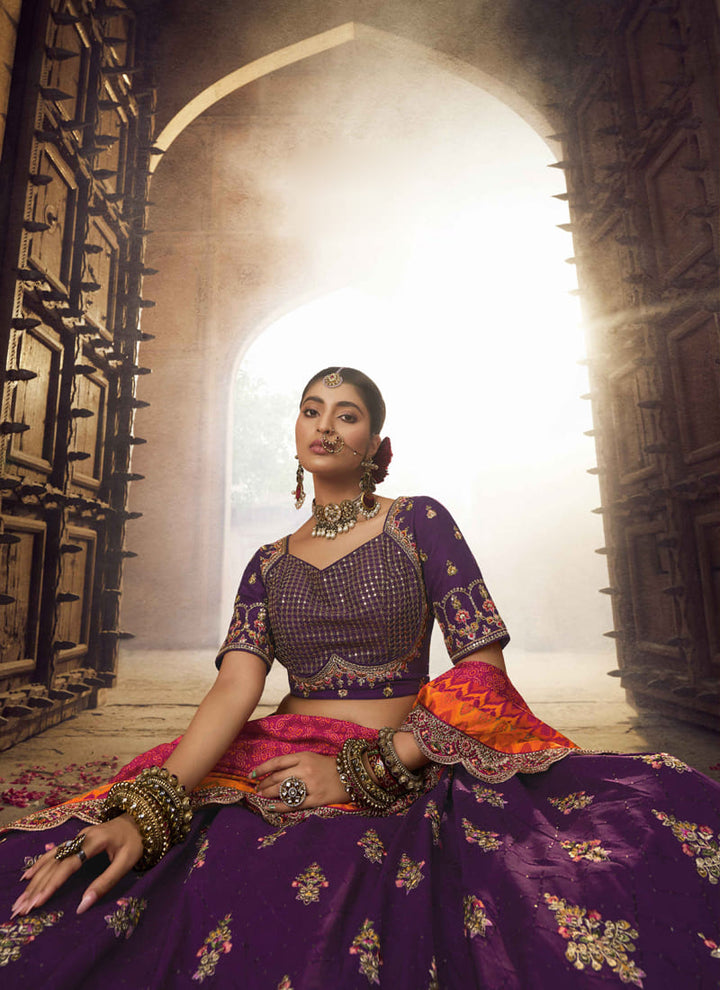 Image: Women in Purple Designer Wedding Wear Lehenga Choli with Embroidery Work. The lehenga choli is in a beautiful shade of purple and adorned with intricate embroidery work. This ensemble exudes elegance and charm, making it a perfect choice for a wedding or special occasion.