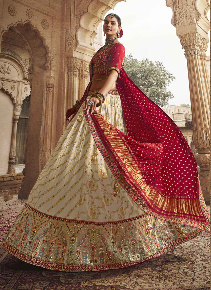 Image: Women in Crimson Red & Off White Color Designer Wedding Wear Lehenga Choli with Weaving Work. The lehenga choli showcases a striking combination of crimson red and off white colors. It features exquisite weaving work, adding intricate patterns and textures to the ensemble. This attire exudes elegance and is perfect for a wedding or any special occasion.