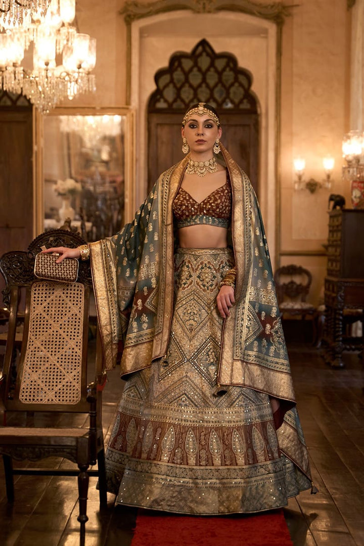 Image: Woman in Beige Color Sparkling Rajwadi Silk Lehenga with Mirror Work Blouse. This dazzling lehenga ensemble features a beige color, crafted from luxurious Rajwadi silk. The blouse is adorned with intricate mirror work, adding a touch of sparkle and glamour. Perfect for special occasions, this attire radiates elegance and can be found in various Indian clothing stores offering Rajwadi silk lehengas.