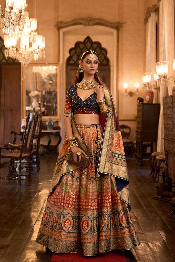 Image: Woman in Multicolor Color Sparkling Rajwadi Silk Lehenga with Mirror Work Blouse. This dazzling lehenga ensemble features a beige color, crafted from luxurious Rajwadi silk. The blouse is adorned with intricate mirror work, adding a touch of sparkle and glamour. Perfect for special occasions, this attire radiates elegance and can be found in various Indian clothing stores offering Rajwadi silk lehengas.