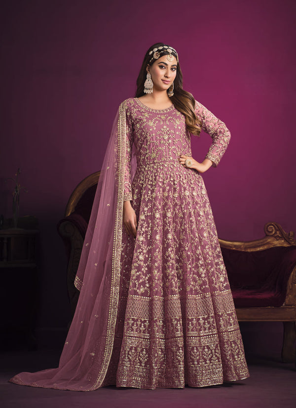 Image: Woman in Pink Color Sparkling Rajwadi Silk Lehenga with Mirror Work Blouse. This mesmerizing lehenga ensemble features a captivating pink color, crafted from luxurious Rajwadi silk. The blouse is beautifully adorned with intricate mirror work, adding a touch of sparkle and elegance. Perfect for special occasions, this attire exudes grace and charm, and it can be found in various Indian clothing stores offering Rajwadi silk lehengas.