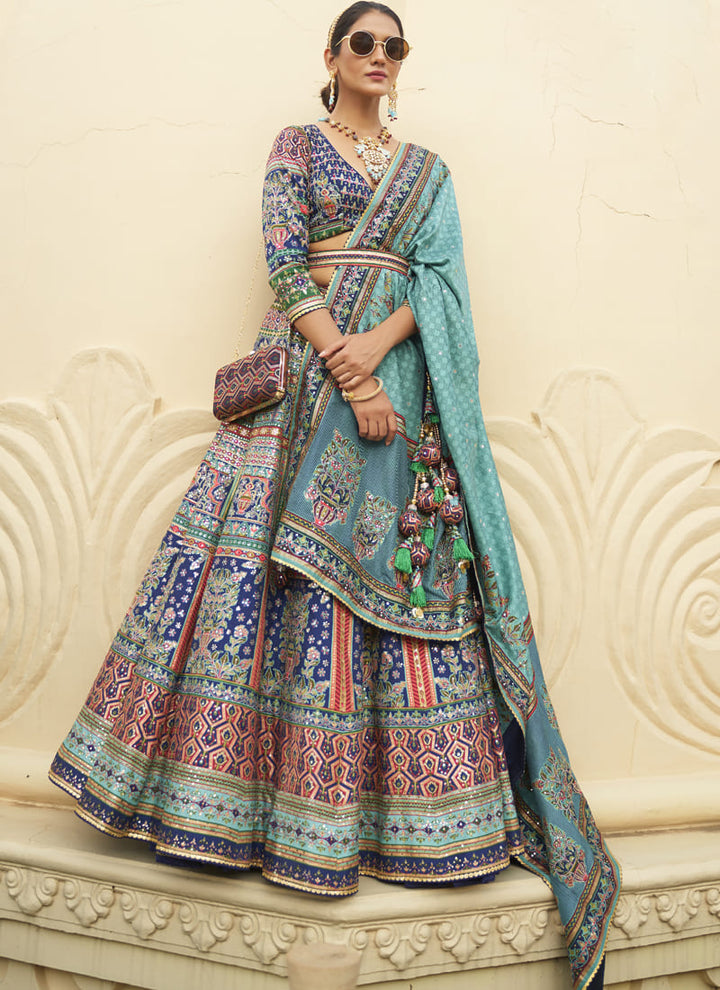 Image: Women in Purssian Blue Radiant Smooth Rajwadi Silk Lehenga Choli. This mesmerizing ensemble showcases a radiant and smooth texture, made from luxurious Rajwadi silk. The lehenga choli exudes elegance and charm, perfect for special occasions and weddings. With its exquisite craftsmanship and glamorous appeal, this outfit is sure to make the wearer stand out with sophistication and style.