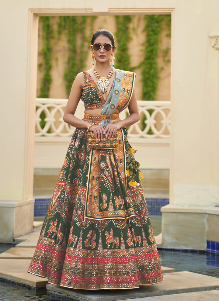 Image: Women in Green Radiant Smooth Rajwadi Silk Lehenga Choli. This mesmerizing ensemble showcases a radiant and smooth texture, made from luxurious Rajwadi silk. The lehenga choli exudes elegance and charm, perfect for special occasions and weddings. With its exquisite craftsmanship and glamorous appeal, this outfit is sure to make the wearer stand out with sophistication and style.