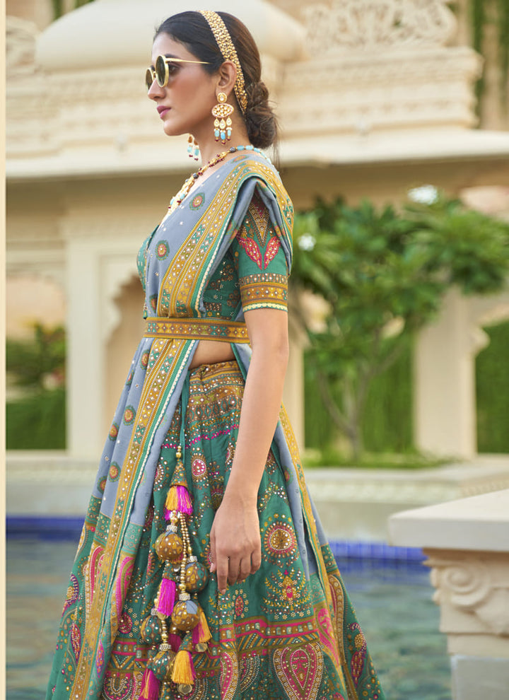 Image: Women in Turquoise Blue Radiant Smooth Rajwadi Silk Lehenga Choli. This mesmerizing ensemble showcases a radiant and smooth texture, made from luxurious Rajwadi silk. The lehenga choli exudes elegance and charm, perfect for special occasions and weddings. With its exquisite craftsmanship and glamorous appeal, this outfit is sure to make the wearer stand out with sophistication and style.
